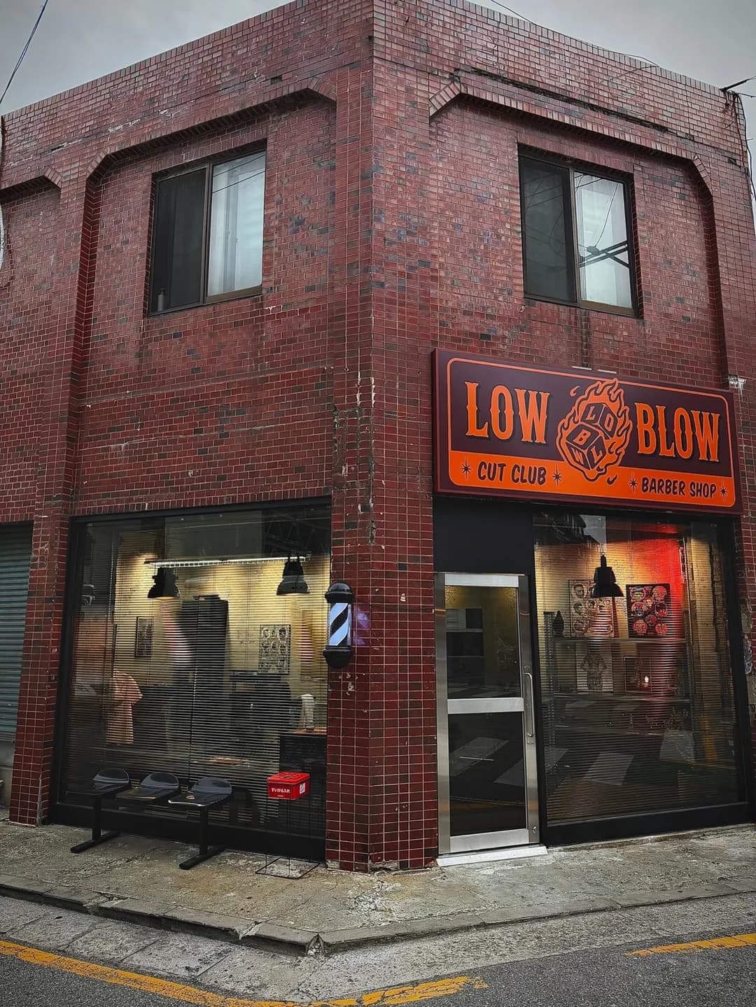 붉은 벽돌 건물 1층의 로우블로우 바버샵 외관과 LOW BLOW 간판